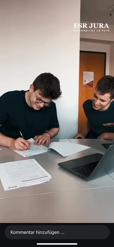 Einblick in die gemeinsame Arbeit an Unterlagen neben einem Laptop.