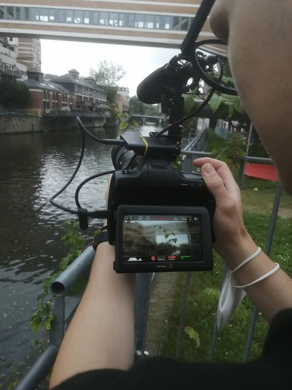 Blick über eine Kamera mit Mikrofon auf eine Szene am Wasser.