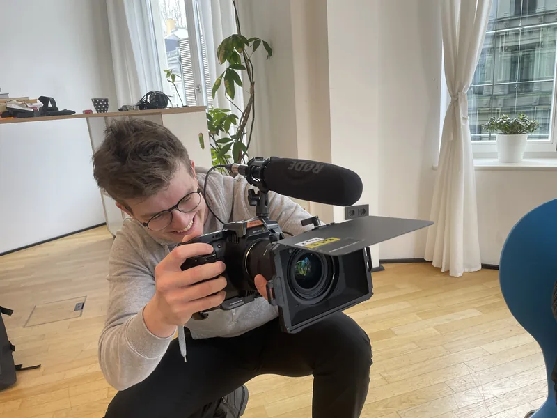 Kameraaufnahme in einem hellen Raum mit Fenstern.