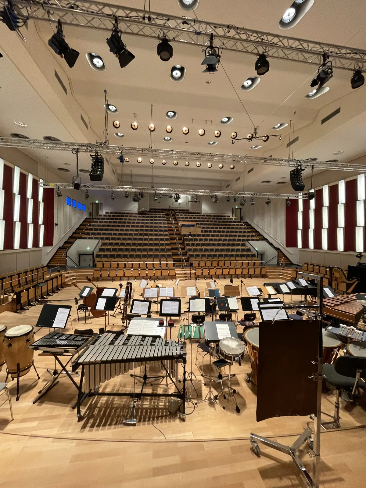 Aufnahmeaufbau mit Instrumenten und Mikrofonen in einem leeren Konzertsaal.