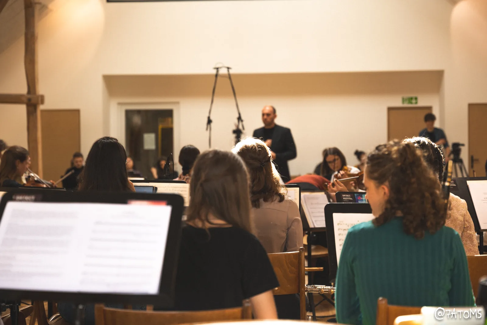 Blick über die Notenpulte auf eine Orchesteraufnahme mit aufgestellten Mikrofonen.