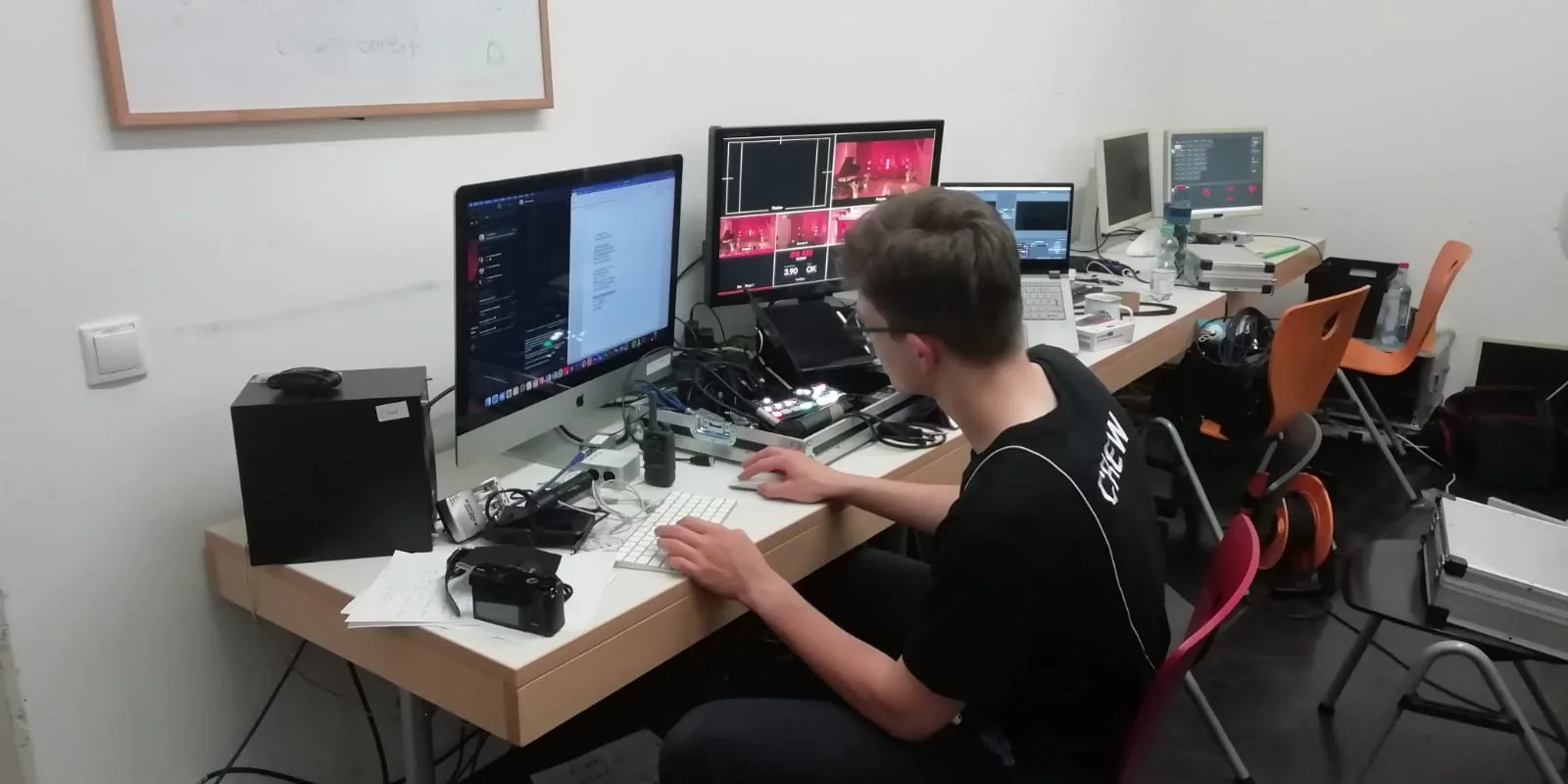 Arbeitsplatz einer Bildregie mit mehreren Bildschirmen während einer Bühnenaufnahme.