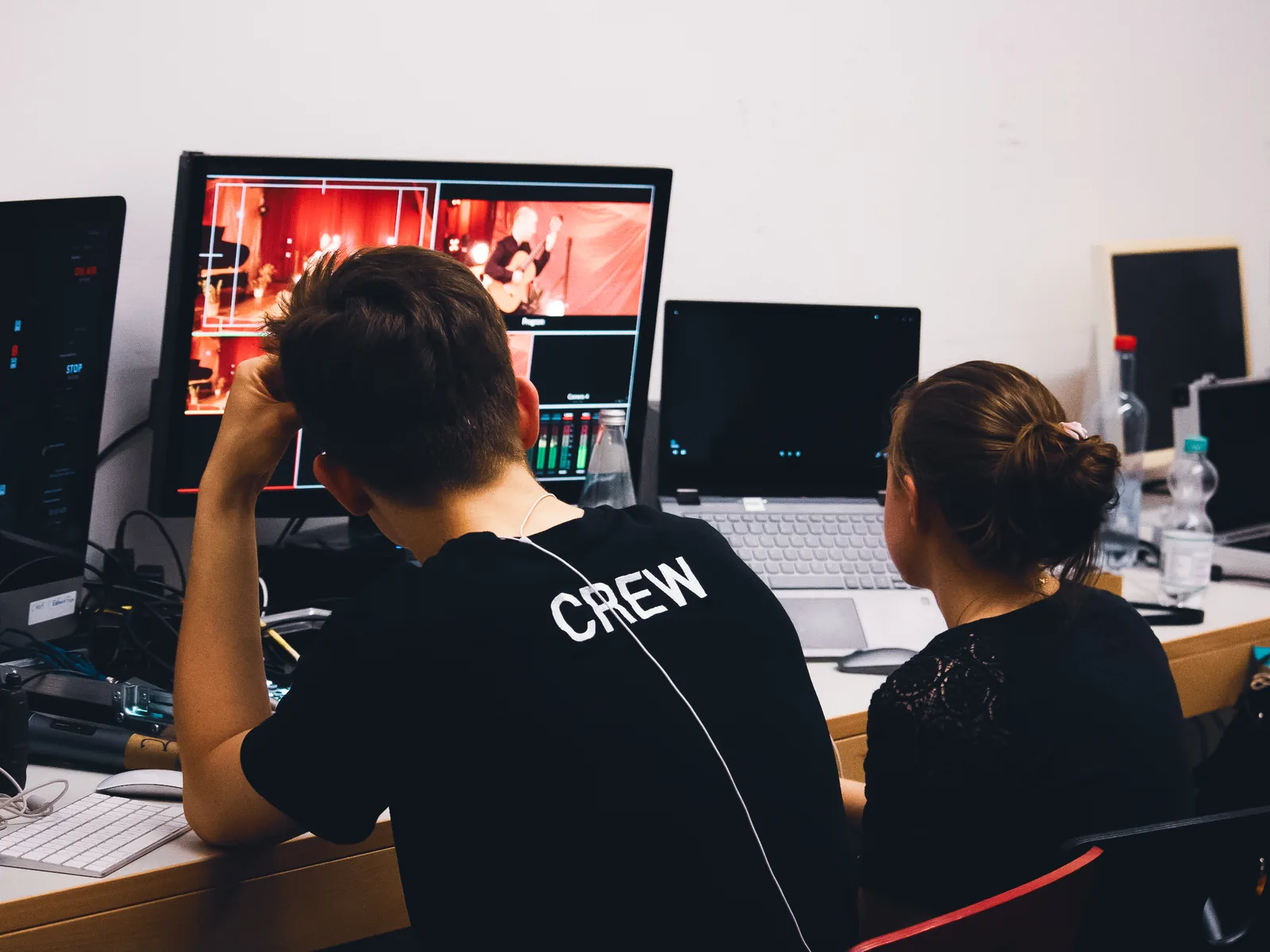 Zwei Personen an der Bildregie mit einer Konzertaufnahme auf dem Kontrollmonitor.